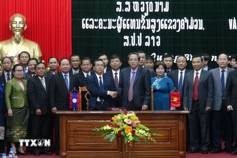 Đại diện hai tỉnh Quảng Bình-Khammuane (Lào) ký biên bản giao ước ngoại giao. (Ảnh: Đức Thọ/TTXVN)