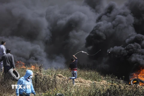 Người biểu tình Palestine đốt lốp xe và ném đá vào binh sỹ Israel. (Nguồn: THX/TTXVN)