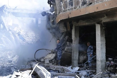 Lính cứu hỏa Syria tại Trung tâm nghiên cứu khoa học bị liên quân đánh phá (Nguồn: AP)