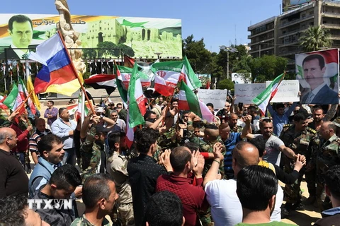 Người dân Syria đổ xuống đường phố Aleppo bày tỏ sự ủng hộ Tổng thống Bashar al-Assad và quân đội Chính phủ. (Nguồn: AFP/TTXVN)