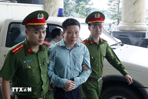 Cảnh sát dẫn giải bị cáo Hà Văn Thắm đến tòa. (Ảnh: Lâm Khánh/TTXVN)