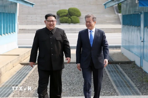 Nhà lãnh đạo Triều Tiên Kim Jong-un (trái) và Tổng thống Hàn Quốc Moon Jae-in bắt tay hữu nghị tại làng đình chiến Panmunjom. (Nguồn: YONHAP/TTXVN)