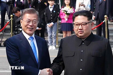 Tổng thống Hàn Quốc Moon Jae-in (trái) bắt tay hữu nghị Nhà lãnh đạo Triều Tiên Kim Jong-un (phải) tại làng đình chiến Panmunjom. (Nguồn: YONHAP/TTXVN)