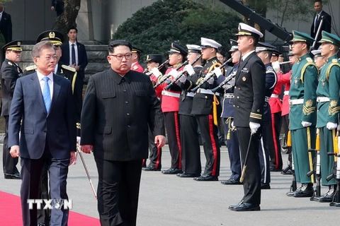 Tổng thống Hàn Quốc Moon Jae-in (trái, phía trước) và Nhà lãnh đạo Triều Tiên Kim Jong-un (phải, phía trước) duyệt đội danh dự tại quảng trường ở làng đình chiến Panmunjom. (Nguồn: YONHAP/TTXVN)