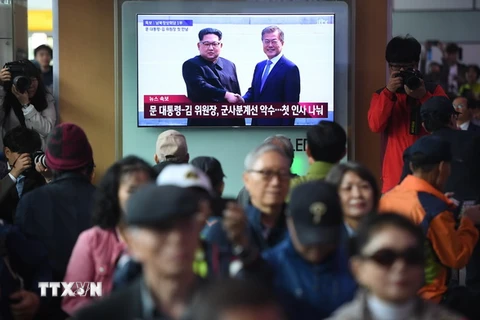 Người dân Hàn Quốc theo dõi hình ảnh Tổng thống Hàn Quốc Moon Jae-in (phải) và Nhà lãnh đạo Triều Tiên Kim Jong-un (trái) bắt tay nhau tại đường ranh giới phân định hai miền. (Nguồn: AFP/TTXVN)