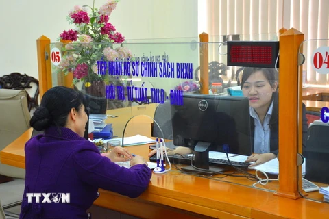 Các cán bộ công tại phòng giao dịch một cửa tại Bảo hiểm xã hội tỉnh Nam Định. (Ảnh Công Luật/TTXVN)