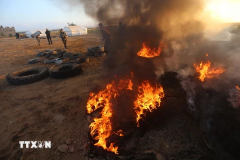 Người Palestine đốt lốp xe trong cuộc biểu tình tại khu vực biên giới Dải Gaza với Israel. (Nguồn: THX/TTXVN)