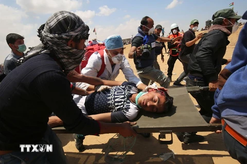 Chuyển người biểu tình Palestine bị thương sau các cuộc đụng độ với binh sỹ Israel tại khu vực biên giới Dải Gaza với Israel. (Nguồn: AFP/TTXVN)