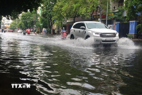Mưa lớn gây ngập tại đường Thanh Loan (Quận 8), khiến phương tiện lưu thông khó khăn. (Ảnh: Anh Tuấn/TTXVN)