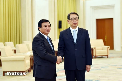 Bí thư Trung ương Đảng Nguyễn Xuân Thắng và ông Trần Hy bắt tay thân mật. (Ảnh: Lương Tuấn/Vietnam+)