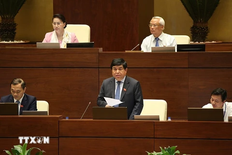 Bộ trưởng Bộ Kế hoạch và Đầu tư Nguyễn Chí Dũng báo cáo làm rõ vấn đề đại biểu Quốc hội nêu. Ảnh: Dương Giang - TTXVN