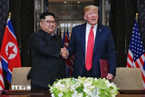 Nhà lãnh đạo Triều Tiên Kim Jong-un (trái) và Tổng thống Mỹ Donald Trump tại cuộc gặp thượng đỉnh hôm 12/6. (Nguồn: EPA/TTXVN)