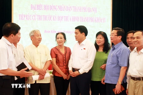 Chủ tịch Ủy ban Nhân dân thành phố Hà Nội Nguyễn Đức Chung cùng các cử tri Quận Hoàn Kiếm. (Ảnh: Văn Cảnh/TTXVN)
