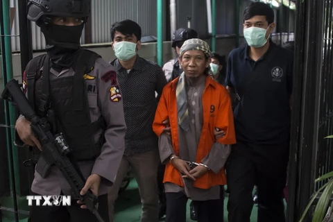 Cảnh sát vũ trang Indonesia áp giải giáo sỹ Hồi giáo cực đoan Aman Abdurrahman (áo cam) tới Tòa án Nam Jakarta. (Nguồn: AFP/TTXVN)
