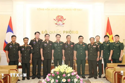 Thượng tướng Lê Chiêm và Đại tá Kanthong Sucluonkhan chụp ảnh lưu niệm cùng các đại biểu. Ảnh: Hồng Pha/TTXVN phát)