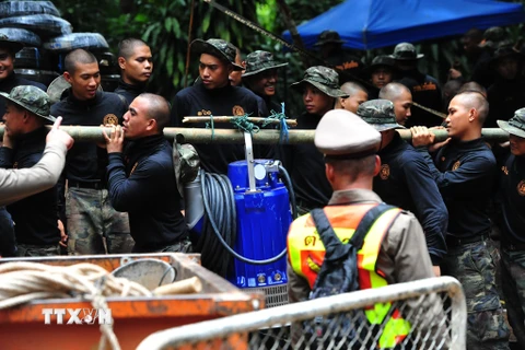 Lực lượng cứu hộ chuyển đường ống nước lớn vào hang động Tham Luang. (Nguồn: THX/TTXVN)