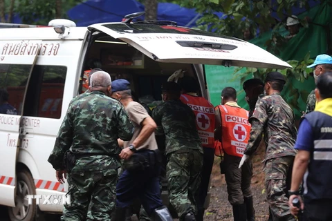 Nhân viên cứu hộ chuyển các thành viên đội bóng sau khi được cứu khỏi hang Tham Luang lên xe cứu thương. (Nguồn: EPA/TTXVN)