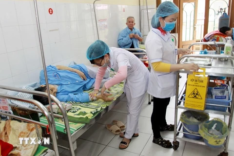 Các bác sỹ Bệnh viện Đa khoa tỉnh Thái Bình điều trị cho các bệnh nhân. (Ảnh: Thế Duyệt/TTXVN)