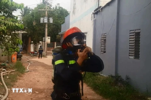 Chiến sỹ Cảnh sát phòng cháy chữa cháy đeo mặt nạ chống khí độc tiếp cận hiện trường. (Ảnh: Nguyễn Văn Việt/TTXVN)