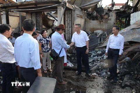 Đại sứ Vũ Quang Minh (thứ hai từ phải sang) đến thị sát và thăm hỏi kiều bào sau vụ cháy. (Ảnh: Nhóm PV TTXVN thường trú tại Campuchia)