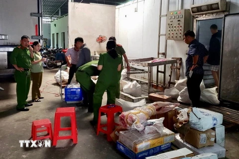 Công an thành phố Cần Thơ kiểm tra và thu giữ hàng chục tấn thực phẩm không rõ nguồn gốc tại cơ sở Hồng Thắm. (Ảnh: Thanh Sang/TTXVN)