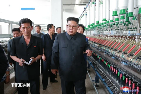 Nhà lãnh đạo Triều Tiên (phải) thăm nhà máy dệt ở Sinuiju. (Ảnh: Yonhap/TTXVN)