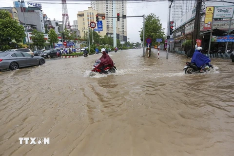 Ngập lụt tại khu vực ngã tư Tố Hữu-Lương Thế Vinh. (Ảnh: Lê Minh Sơn/TTXVN phát)