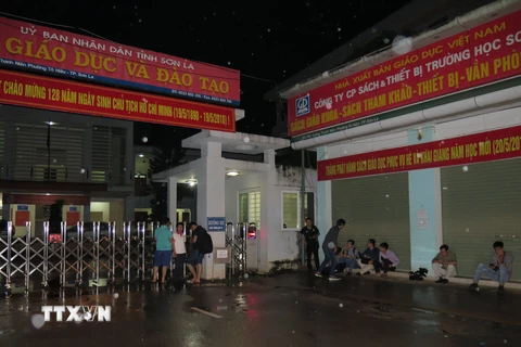 Phóng viên các cơ quan thông tấn, báo chí tác nghiệp trước cổng Sở Giáo dục và Đào tạo Sơn La. (Ảnh: Hữu Quyết/TTXVN)