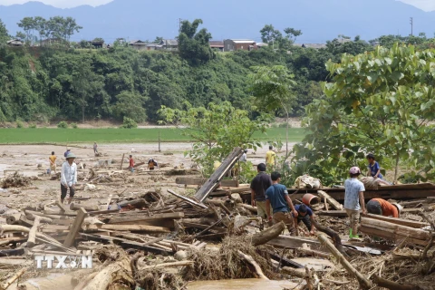 Người dân đang tích cực thu dọn khắc phục hậu quả do mưa lũ tàn phá. (Ảnh: Việt Dũng/TTXVN)