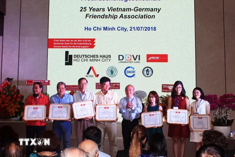Ông Huỳnh Minh Thiện, Chủ tịch Liên hiệp các tổ chức hữu nghị Thành phố Hồ Chí Minh trao tặng Bằng khen cho các cá nhân, đại diện tập thể có thành tích đóng góp cho sự phát triển của Hội. (Ảnh: Xuân Khu/TTXVN)