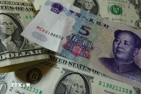 Đồng USD và nhân dân tệ. (Nguồn: AFP/TTXVN)