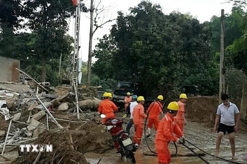 Công nhân Điện lực Yên Bái đang khẩn trương sửa chữa lại hệ thống lưới điện bị hư hỏng sau mưa lũ. (Ảnh: TTXVN phát)