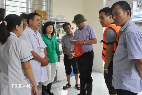 Đoàn kiểm tra công tác đáp ứng y tế cho người dân vùng ngập lụt tại Trạm y tế dã chiến xã Nam Hải, huyện Chương Mỹ. (Ảnh: Tuyết Mai/TTXVN)