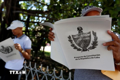 Người dân đọc chuyên san đăng tải Dự thảo Hiến pháp mới của Cuba tại La Habana. (Nguồn: EFE-EPA/TTXVN)