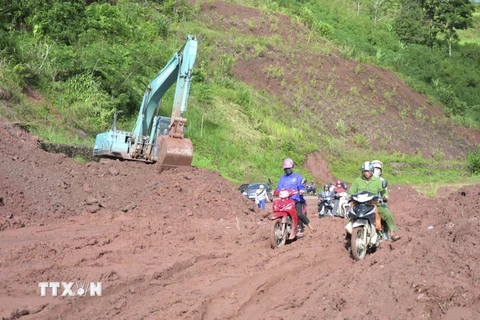 Đơn vị quản lý tuyến Quốc lộ 4H đang dọn sạch bùn nhão trên nền đường, đảm bảo cho các phương tiện giao thông qua lại. (Ảnh: Văn Dũng/TTXVN)