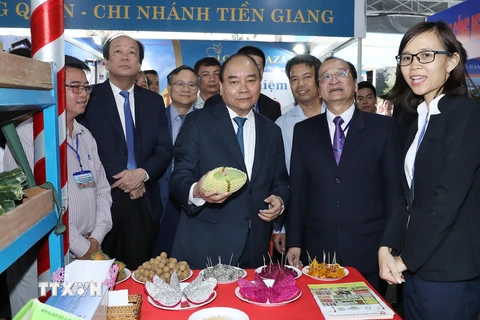 Thủ tướng Nguyễn Xuân Phúc và các đại biểu tham quan gian hàng trưng bày các sản phẩm của tỉnh. (Ảnh: Thống Nhất/TTXVN)