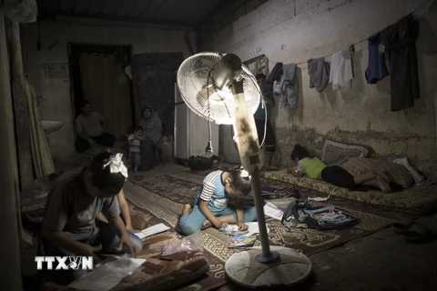 Người dân Palestine sinh hoạt trong điều kiện khó khăn do thiếu điện ở Dải Gaza. (Nguồn: AFP/TTXVN)
