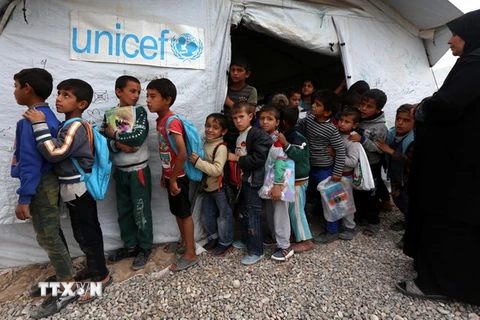 Trẻ em tị nạn Iraq xếp hàng bên ngoài một trường học của Liên hợp quốc tại trại tị nạn Hasan Sham, cách Arbil ở miền bắc Iraq 40km về phía Đông. (Nguồn: AFP/TTXVN)