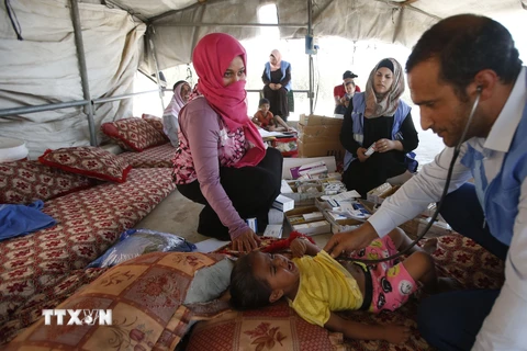 Bác sỹ thuộc UNRWA kiểm tra sức khỏe cho một em nhỏ Palestine tại trại tị nạn ở ngoại ô thành phố Hebron, Bờ Tây. (Nguồn: AFP/TTXVN)