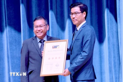 Đại diện QS Stars University Raitings (trái) trao chứng nhận xếp hạng 4 sao cho đại diện lãnh đạo Trường Đại học Tôn Đức Thắng. (Ảnh: Thu Hoài/TTXVN)