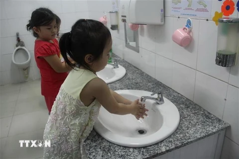 Hướng dẫn trẻ rửa sạch tay trước khi ăn và sau khi vệ sinh tại Trường mầm non phường 1, quận 10. (Ảnh: Đinh Hằng/TTXVN)