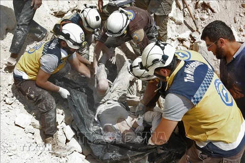 Lực lượng White Helmets chuyển nạn nhân sau một vụ không kích trong xung đột gần Khan Shaykhun, tỉnh Idlib, Syria. (Nguồn: AFP/TTXVN)