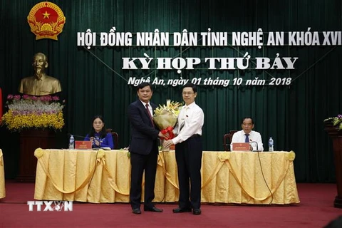 Ông Nguyễn Xuân Sơn - Phó Bí thư Thường trực Tỉnh ủy, Chủ tịch Hội đồng Nhân dân tỉnh tặng hoa chúc mừng ông Thái Thanh Quý. (Ảnh: Bích Huệ/TTXVN)