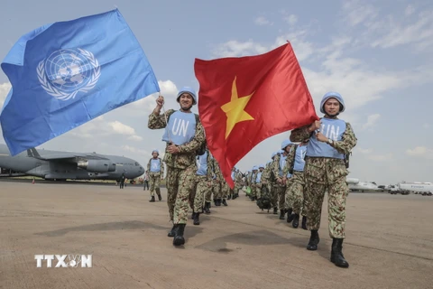Các bác sỹ quân y Việt Nam giương cao hai lá cờ của Liên hợp quốc và Việt Nam tại sân bay quốc tế Juba, bắt đầu thực hiện nhiệm vụ gìn giữ hòa bình Liên hợp quốc tại Nam Sudan. (Ảnh: TTXVN phát)