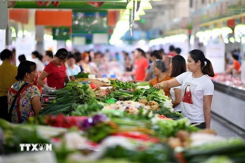 Người dân mua sắm tại một khu chợ ở Hải Nam, Trung Quốc. (Nguồn: AFP/TTXVN)