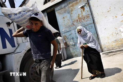 Người dân Palestine nhận lượng thực cứu trợ của UNRWA tại trại tị nạn Rafah ở Dải Gaza. (Nguồn: AFP/TTXVN)