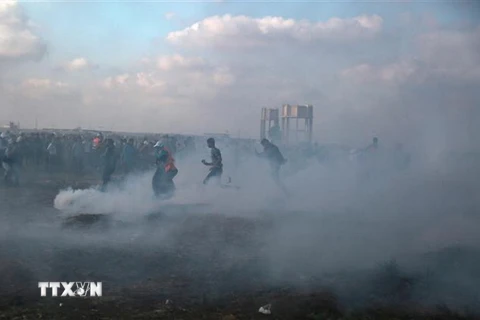 Binh sỹ Israel bắn đạn hơi cay về phía người biểu tình Palestine gần khu vực biên giới Gaza-Israel. (Nguồn: THX/TTXVN)