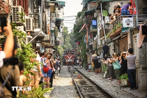 Đoàn tàu Thống Nhất chậm rãi tiến vào Phố đường tàu trong sự phấn khích của du khách. Ai cũng sẵn sàng máy ảnh, điện thoại để lưu lại một khoảnh khắc đáng nhớ. (Ảnh: Trọng Đạt/TTXVN)