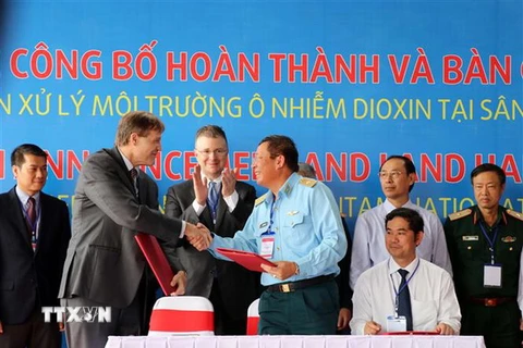 Đại diện USAID (trái) trao thỏa thuận bàn giao diện tích đất qua xử lý cho Quân chủng Phòng không-Không quân. (Ảnh: Nguyễn Sơn/TTXVN)