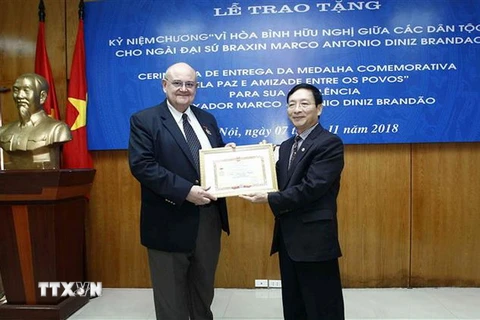 Phó Chủ tịch Liên hiệp các tổ chức hữu nghị Việt Nam Bùi Khắc Sơn trao tặng Kỷ niệm chương Vì hòa bình hữu nghị giữa các dân tộc cho Đại sứ Brazil Marco Antonio Diniz Brandao. (Ảnh: Văn Điệp/TTXVN)